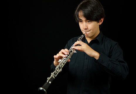 teen playing oboe woodwind music instrument
